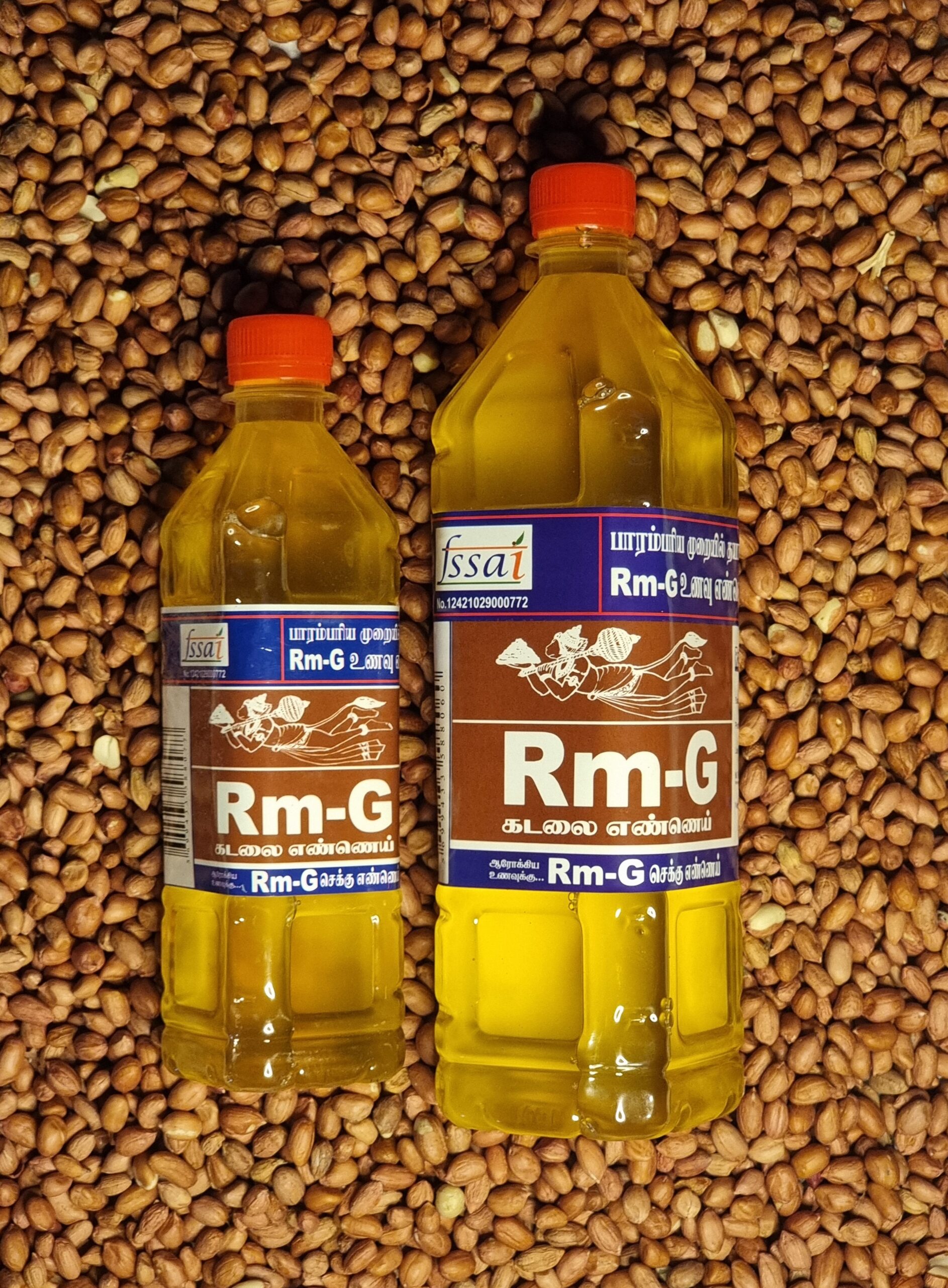 Two Bottles Of Rm-G Unrefined Groundnut Chekku Oil Placed Over Raw Groundnuts